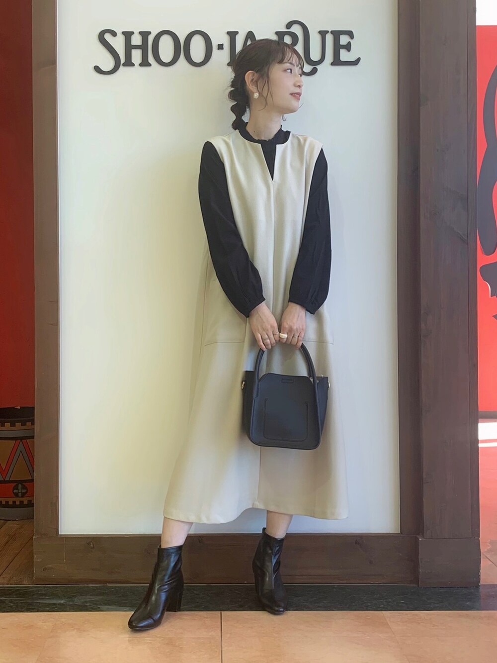 ブラック系のワンピース、ブラック系のシャツ/ブラウス、ブラック系のトートバッグを着用したレディースの冬コーディネートの2枚目の写真