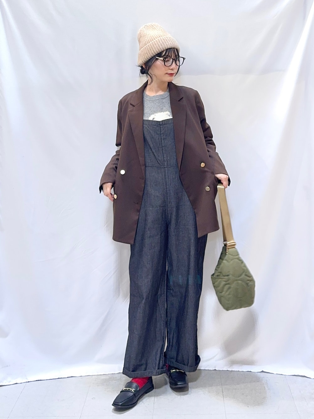 ブラウン系のテーラードジャケット、グレー系のニット/セーター、ブラック系のサロペット/オーバーオールを着用したレディースの秋コーディネートの3枚目の写真