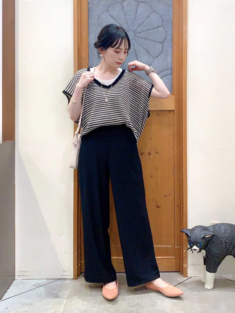 ブラック系のその他トップス、ブラック系のその他パンツ、ホワイト系のショルダーバッグを着用したレディースの春コーディネートの2枚目の写真