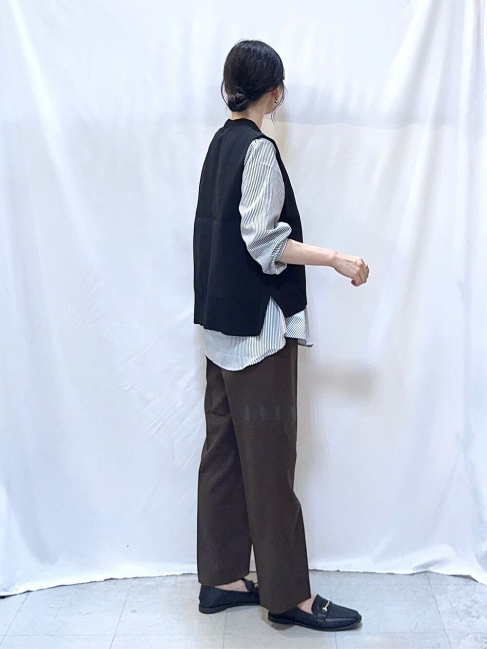 グリーン系のカーディガン/ボレロ、ブラック系のニット/セーター、ブラウン系のその他パンツを着用したレディースの秋コーディネートの7枚目の写真