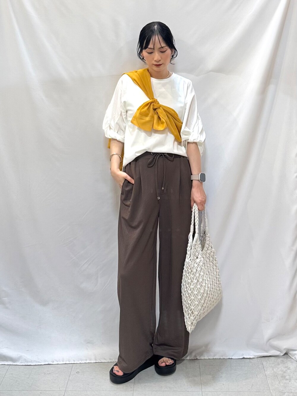 イエロー系のシャツ/ブラウス、ホワイト系のTシャツ/カットソー、ブラウン系のその他パンツを着用したレディースの夏コーディネートの2枚目の写真
