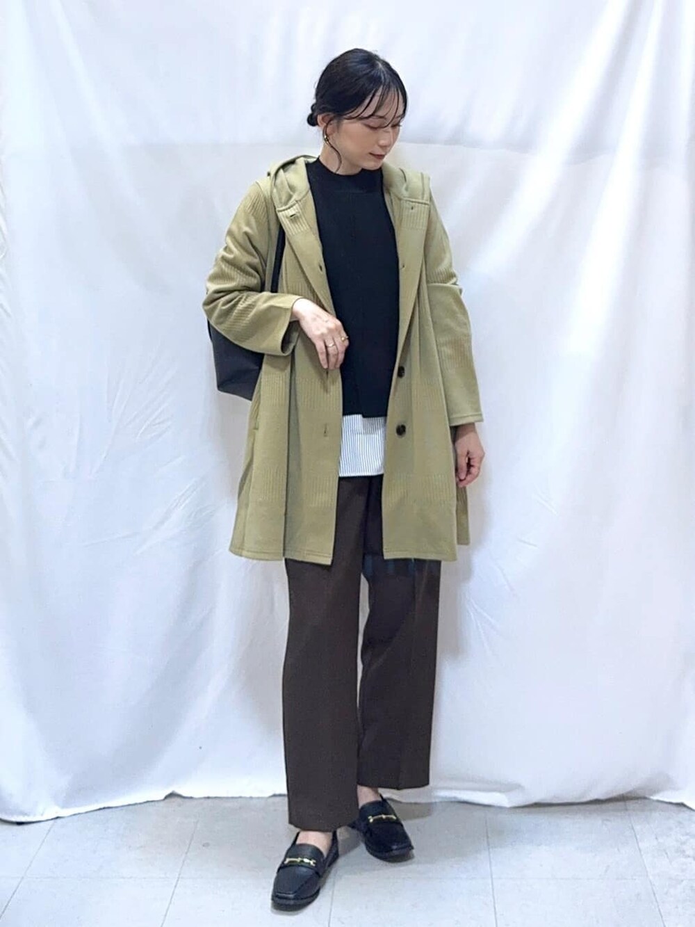 グリーン系のカーディガン/ボレロ、ブラック系のニット/セーター、ブラウン系のその他パンツを着用したレディースの秋コーディネートの2枚目の写真