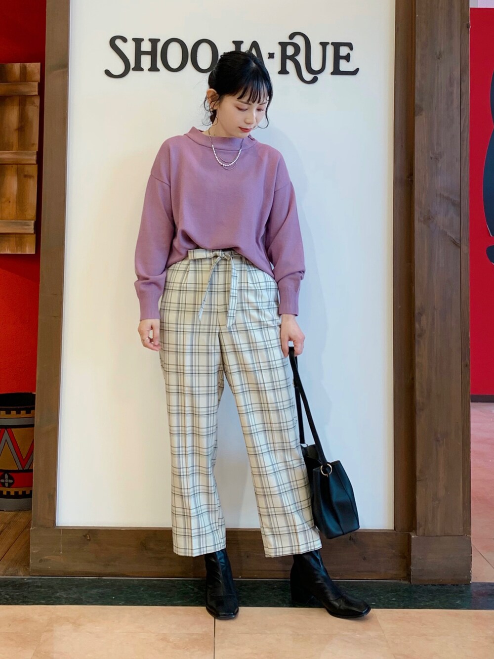 ピンク系のニット/セーター、グレー系のその他パンツ、ブラック系のショルダーバッグを着用したレディースの冬コーディネートの2枚目の写真