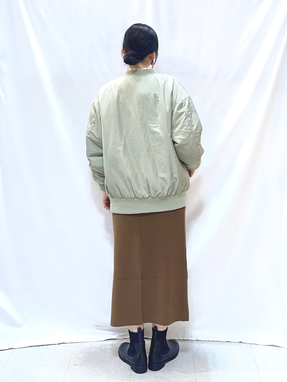 グリーン系のブルゾン、グレー系のスウェット、ホワイト系のTシャツ/カットソーを着用したレディースの冬コーディネートの4枚目の写真