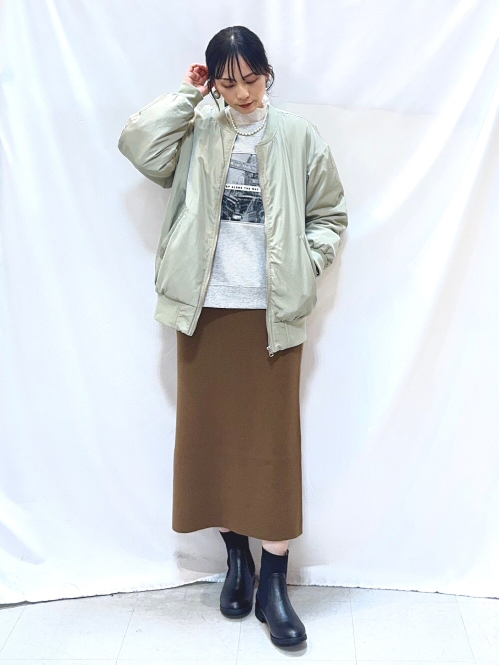 グリーン系のブルゾン、グレー系のスウェット、ホワイト系のTシャツ/カットソーを着用したレディースの冬コーディネートの2枚目の写真