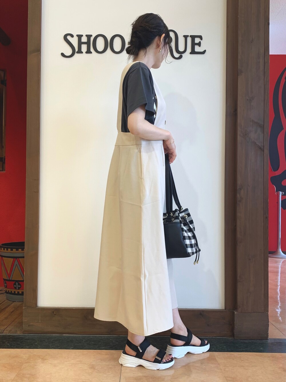 グレー系のTシャツ/カットソー、ベージュ系のスカート、ブラック系のサンダルを着用したレディースの夏コーディネートの2枚目の写真