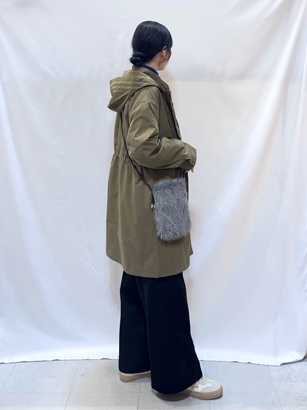 グリーン系のミリタリージャケット、グレー系のニット/セーター、ブルー系のニット/セーターを着用したレディースの冬コーディネートの2枚目の写真