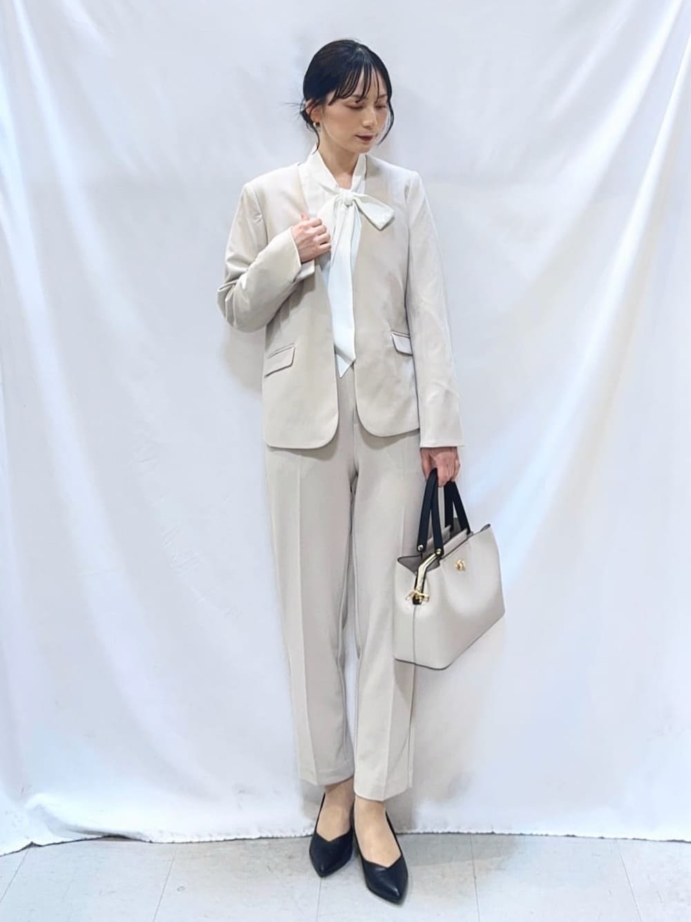 ベージュ系のノーカラージャケット、ホワイト系のシャツ/ブラウス、ベージュ系のその他パンツを着用したレディースの春コーディネートの2枚目の写真