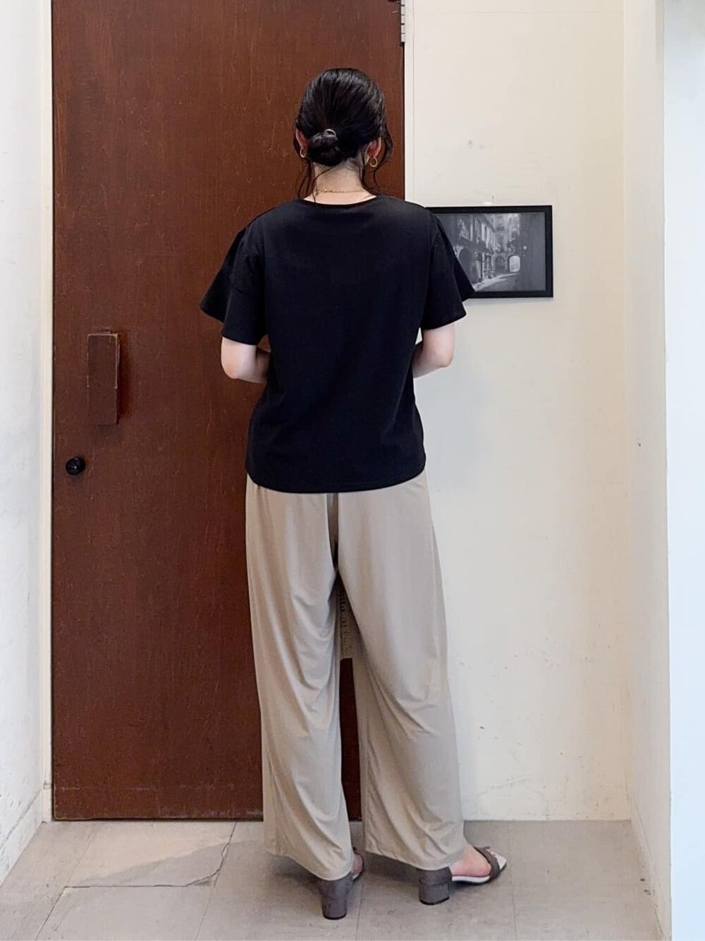 ブラック系のTシャツ/カットソー、ベージュ系のその他パンツ、ベージュ系のサンダルを着用したレディースの夏コーディネートの3枚目の写真