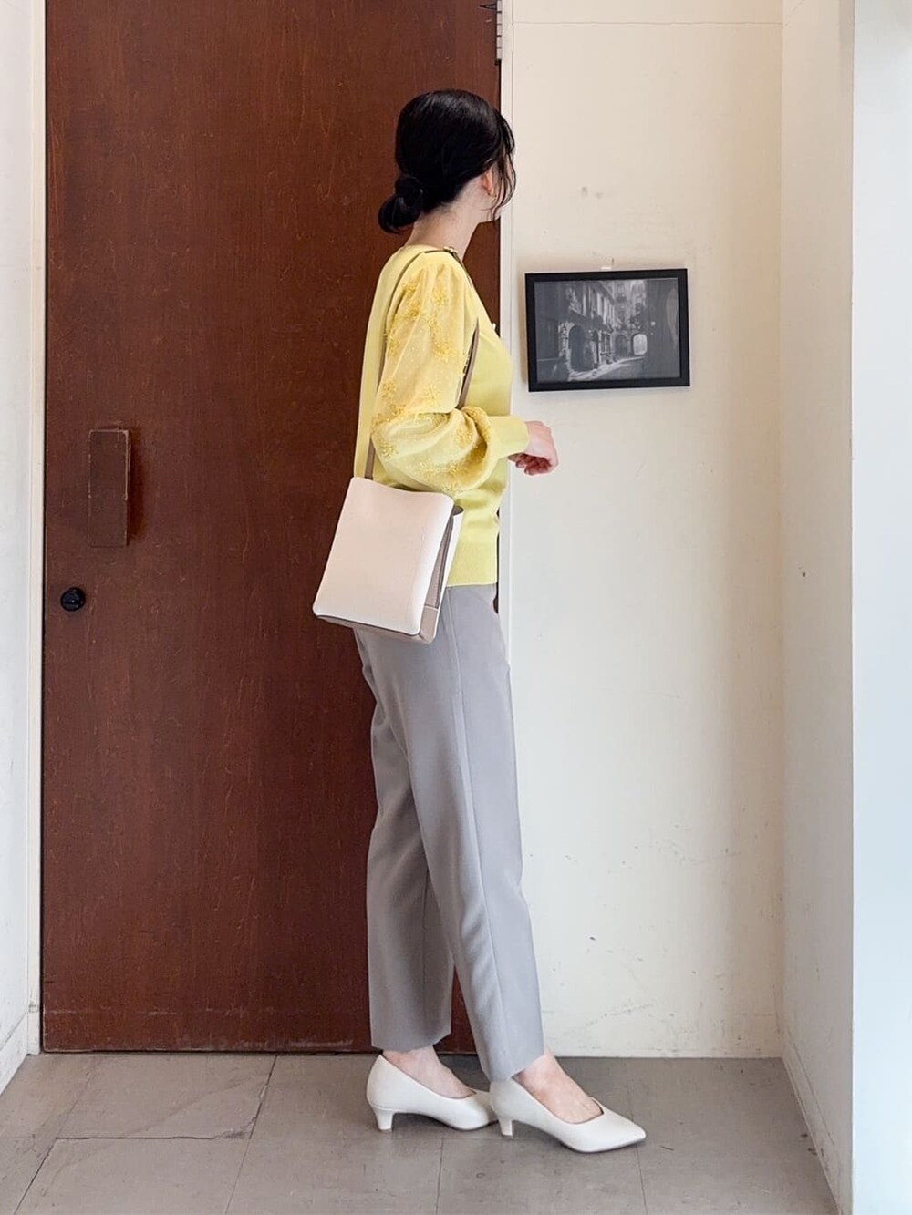 イエロー系のニット/セーター、ブラウン系のその他パンツ、ホワイト系のパンプスを着用したレディースの春コーディネートの3枚目の写真