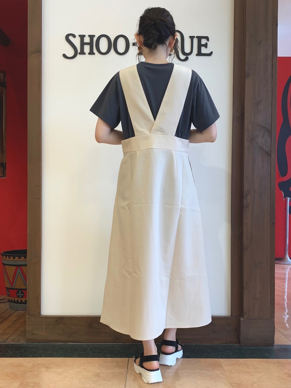 グレー系のTシャツ/カットソー、ベージュ系のスカート、ブラック系のサンダルを着用したレディースの夏コーディネートの3枚目の写真