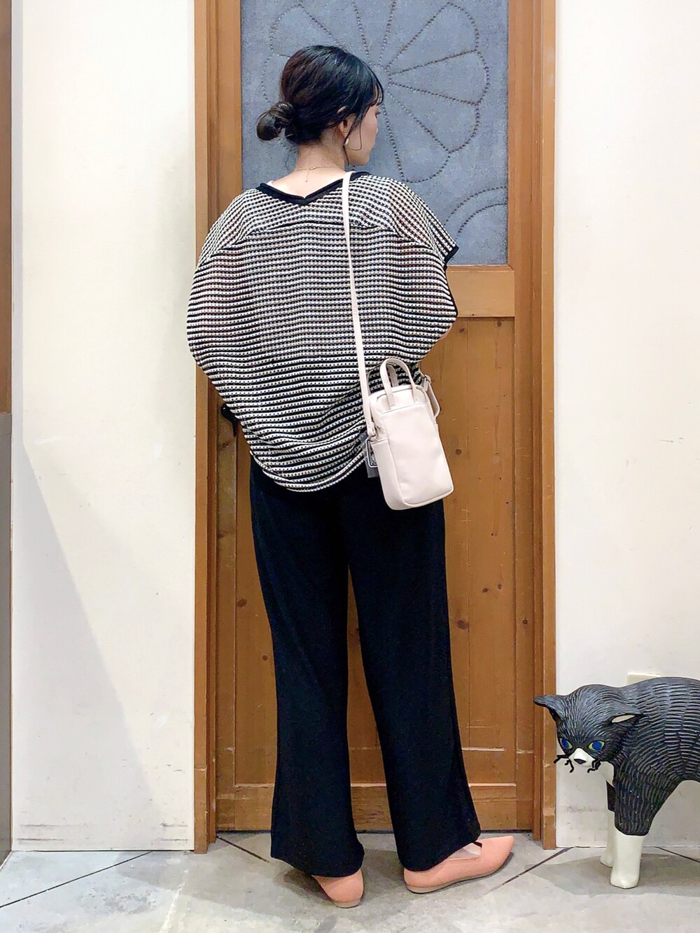 ブラック系のその他トップス、ブラック系のその他パンツ、ホワイト系のショルダーバッグを着用したレディースの春コーディネートの4枚目の写真