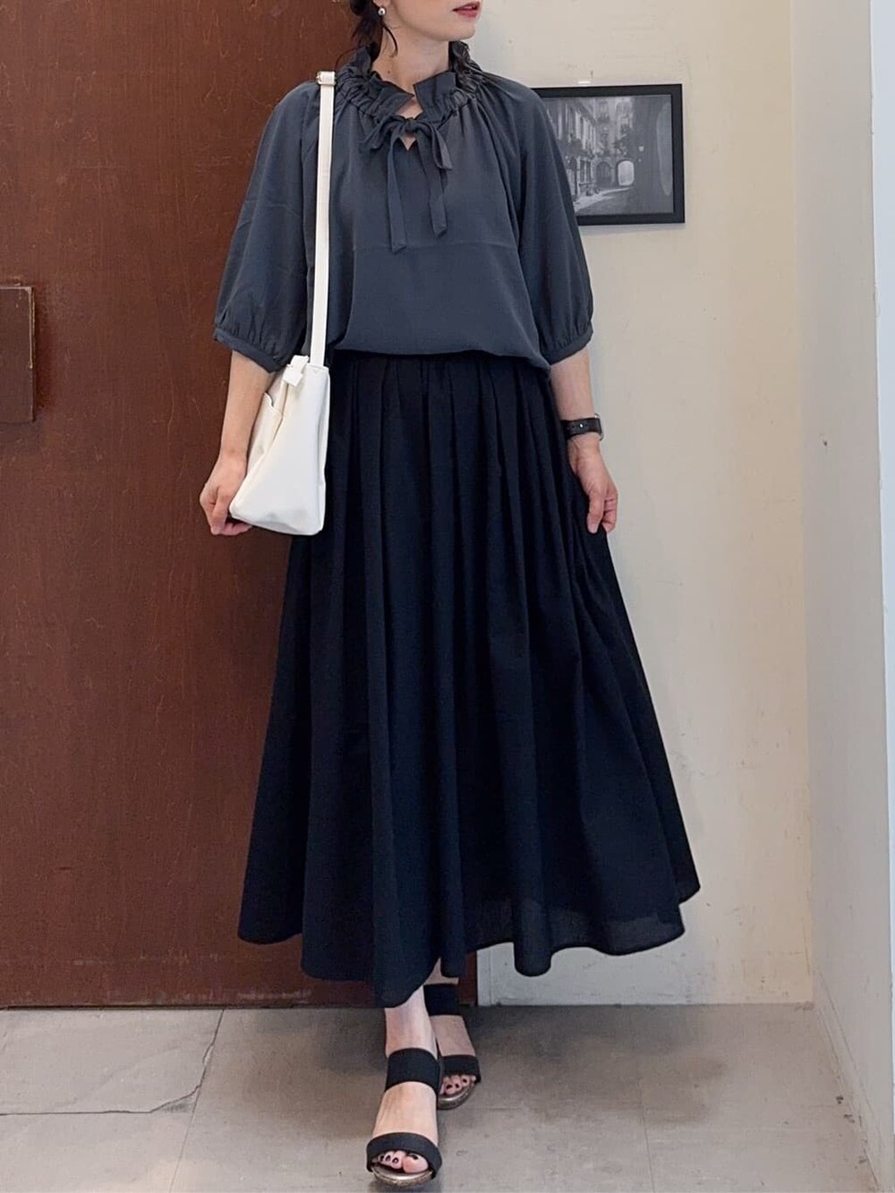 グレー系のシャツ/ブラウス、ブラック系のスカート、ブラック系のサンダルを着用したレディースの夏コーディネートの4枚目の写真