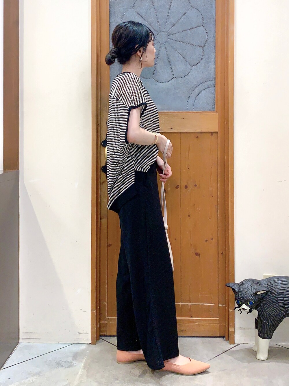 ブラック系のその他トップス、ブラック系のその他パンツ、ホワイト系のショルダーバッグを着用したレディースの春コーディネートの3枚目の写真