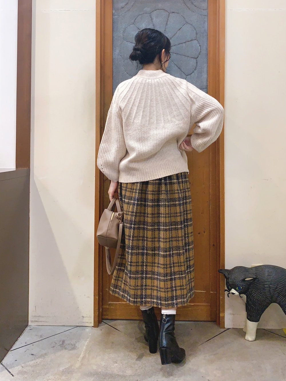 ベージュ系のニット/セーター、イエロー系のスカート、グレー系のショルダーバッグを着用したレディースの冬コーディネートの4枚目の写真