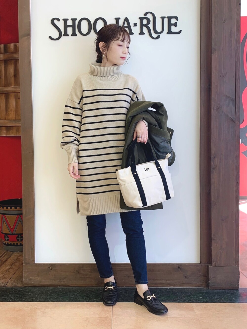 ベージュ系のワンピース、グリーン系のその他アウター、ブラック系のトートバッグを着用したレディースの秋コーディネートの2枚目の写真