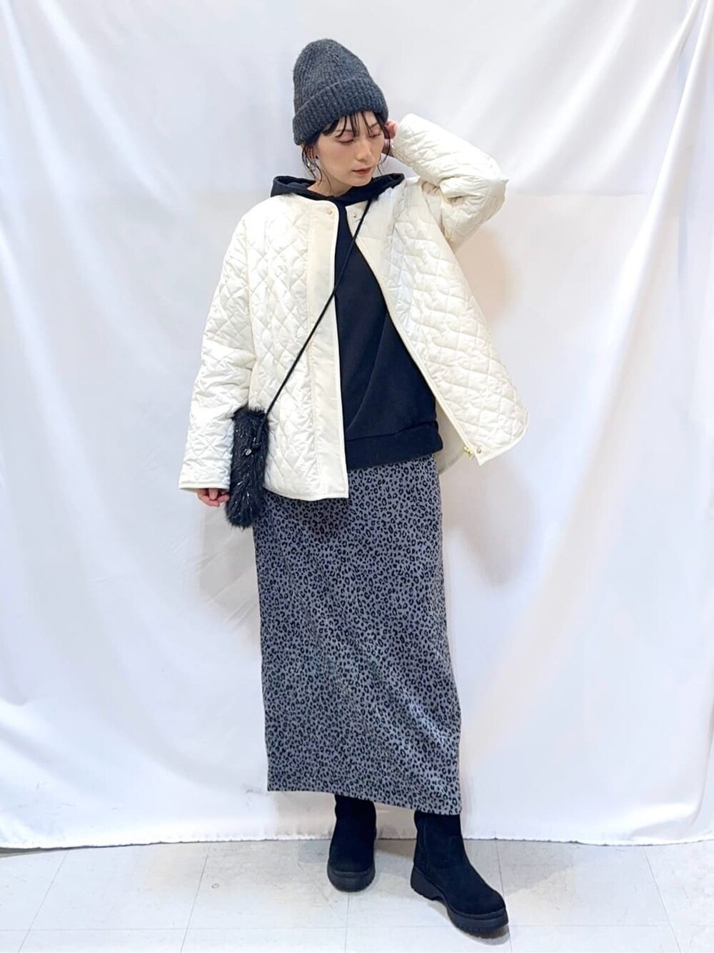 ホワイト系のノーカラージャケット、グレー系のパーカー、グレー系のスカートを着用したレディースの冬コーディネートの5枚目の写真
