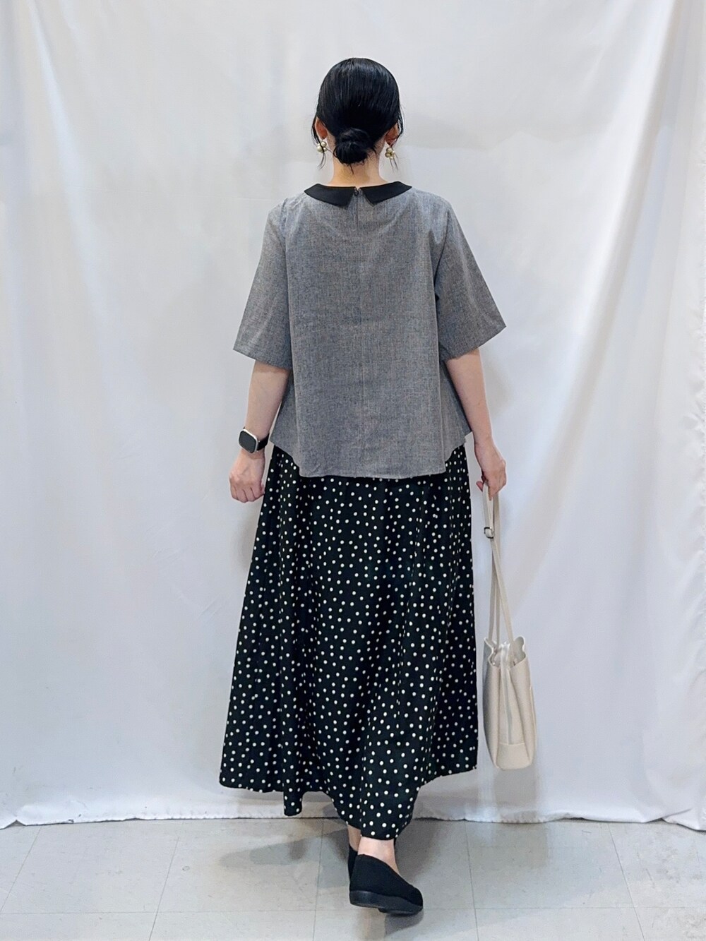 グレー系のシャツ/ブラウス、ブラック系のスカート、ブラック系のパンプスを着用したレディースの夏コーディネートの5枚目の写真