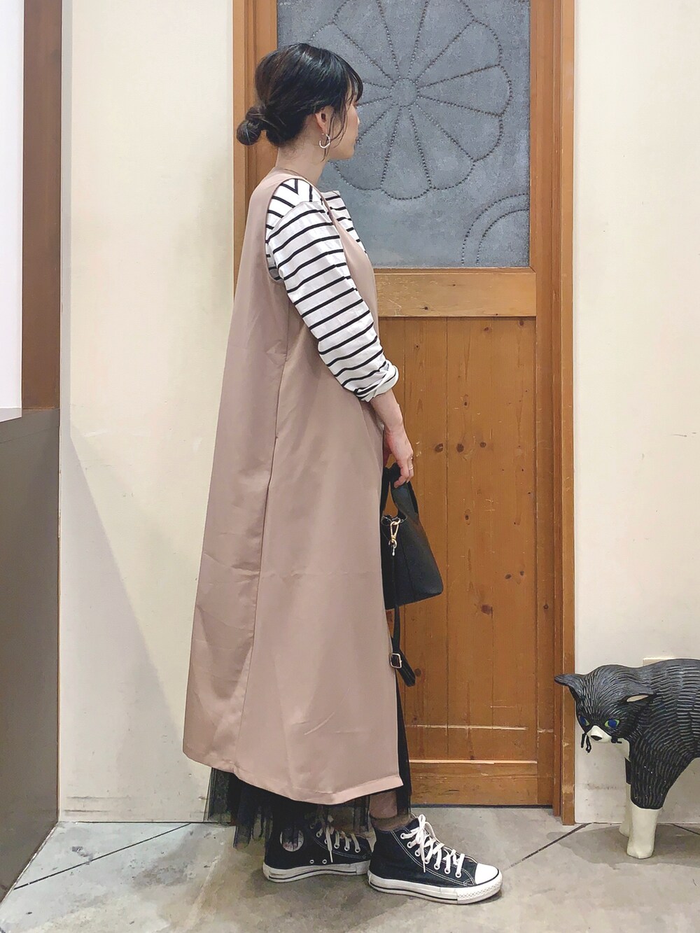 ブラック系のTシャツ/カットソー、ベージュ系のベスト、ブラック系のスカートを着用したレディースの春コーディネートの3枚目の写真