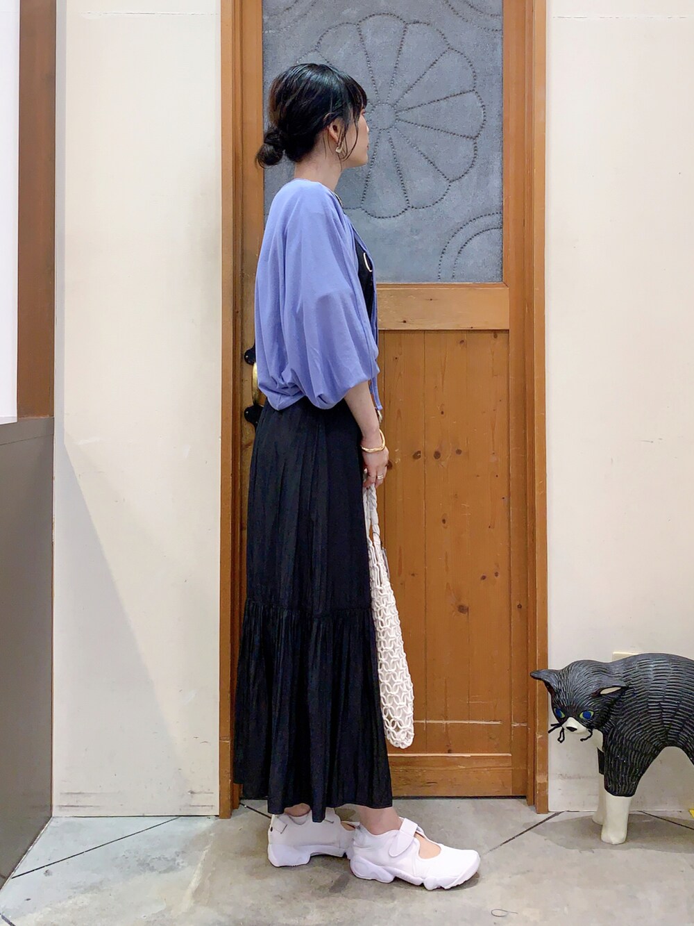 ブラック系のTシャツ/カットソー、ブルー系のカーディガン/ボレロ、ブラック系のスカートを着用したレディースの春コーディネートの3枚目の写真