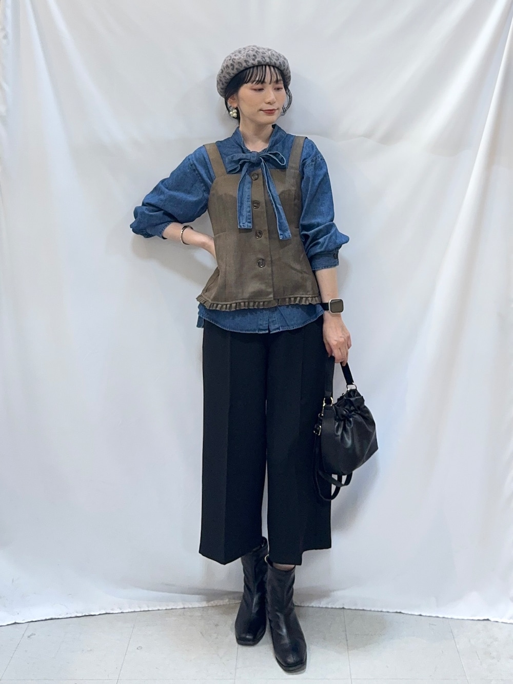 ブルー系のシャツ/ブラウス、ブラック系のその他パンツ、ブラック系のブーツを着用したレディースの秋コーディネートの4枚目の写真