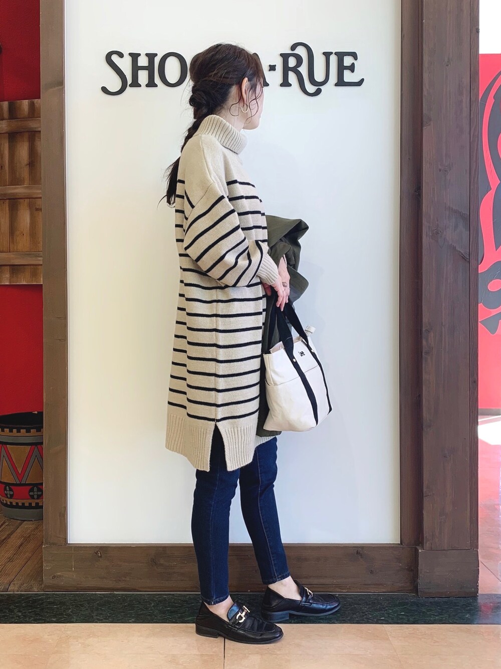 ベージュ系のワンピース、グリーン系のその他アウター、ブラック系のトートバッグを着用したレディースの秋コーディネートの3枚目の写真