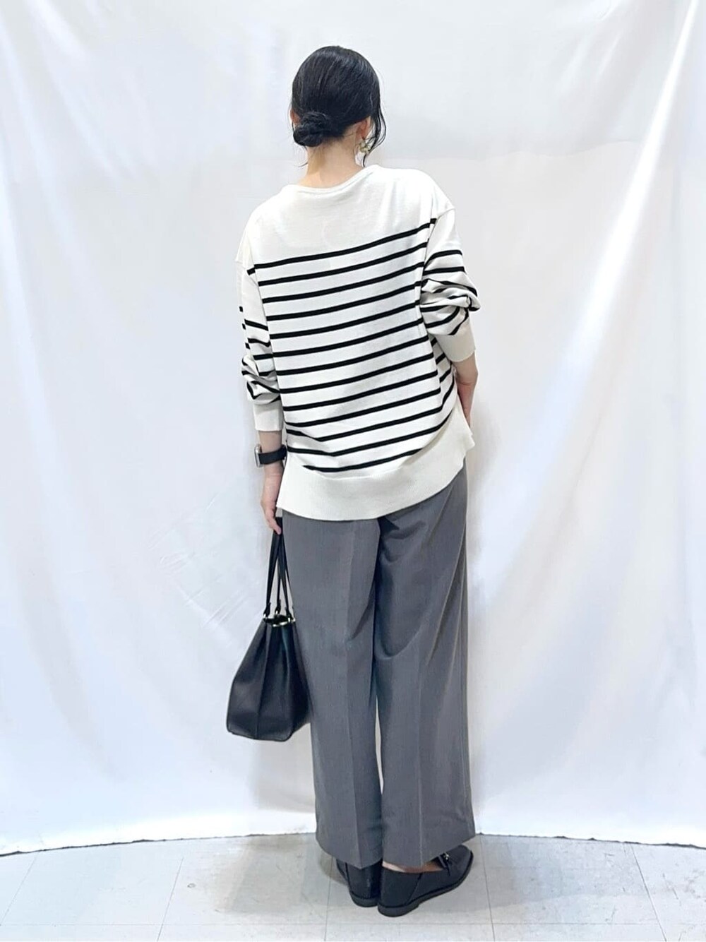ホワイト系のニット/セーター、グレー系のその他パンツ、ブラック系のその他シューズを着用したレディースの秋コーディネートの4枚目の写真