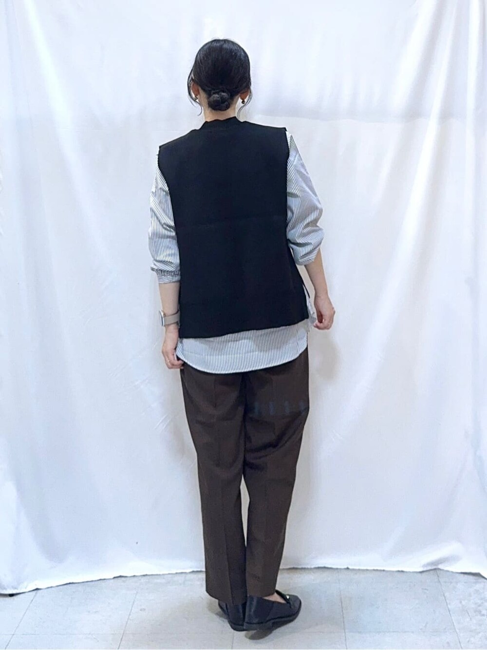 グリーン系のカーディガン/ボレロ、ブラック系のニット/セーター、ブラウン系のその他パンツを着用したレディースの秋コーディネートの8枚目の写真