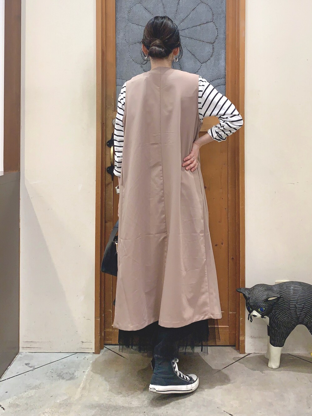 ブラック系のTシャツ/カットソー、ベージュ系のベスト、ブラック系のスカートを着用したレディースの春コーディネートの4枚目の写真