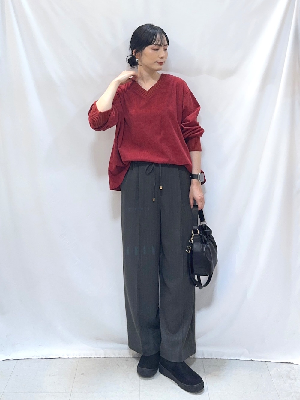 レッド系のTシャツ/カットソー、グレー系のその他パンツ、ブラック系のブーツを着用したレディースの秋コーディネートの4枚目の写真