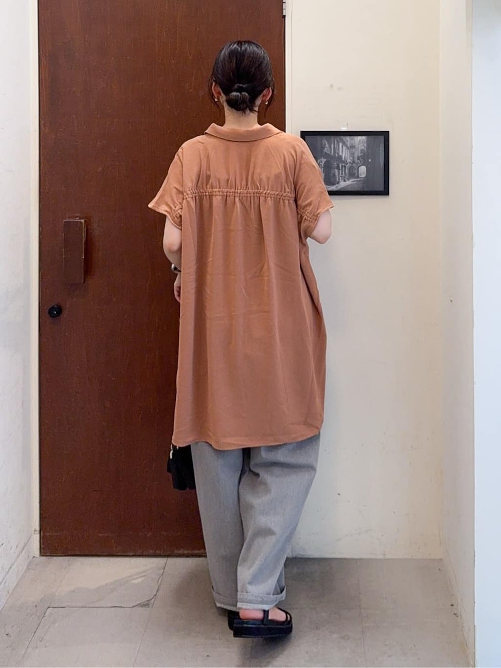 オレンジ系のチュニック、ブラック系のタンクトップ、グレー系のその他パンツを着用したレディースの夏コーディネートの4枚目の写真