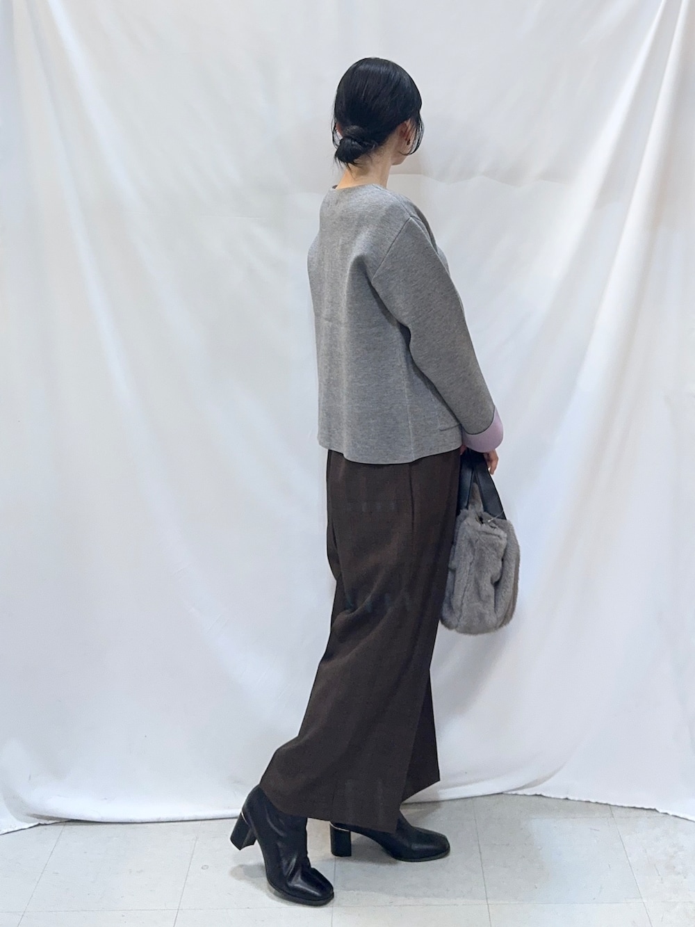 グレー系のカーディガン/ボレロ、ピンク系のニット/セーター、ブラウン系のその他パンツを着用したレディースの秋コーディネートの2枚目の写真