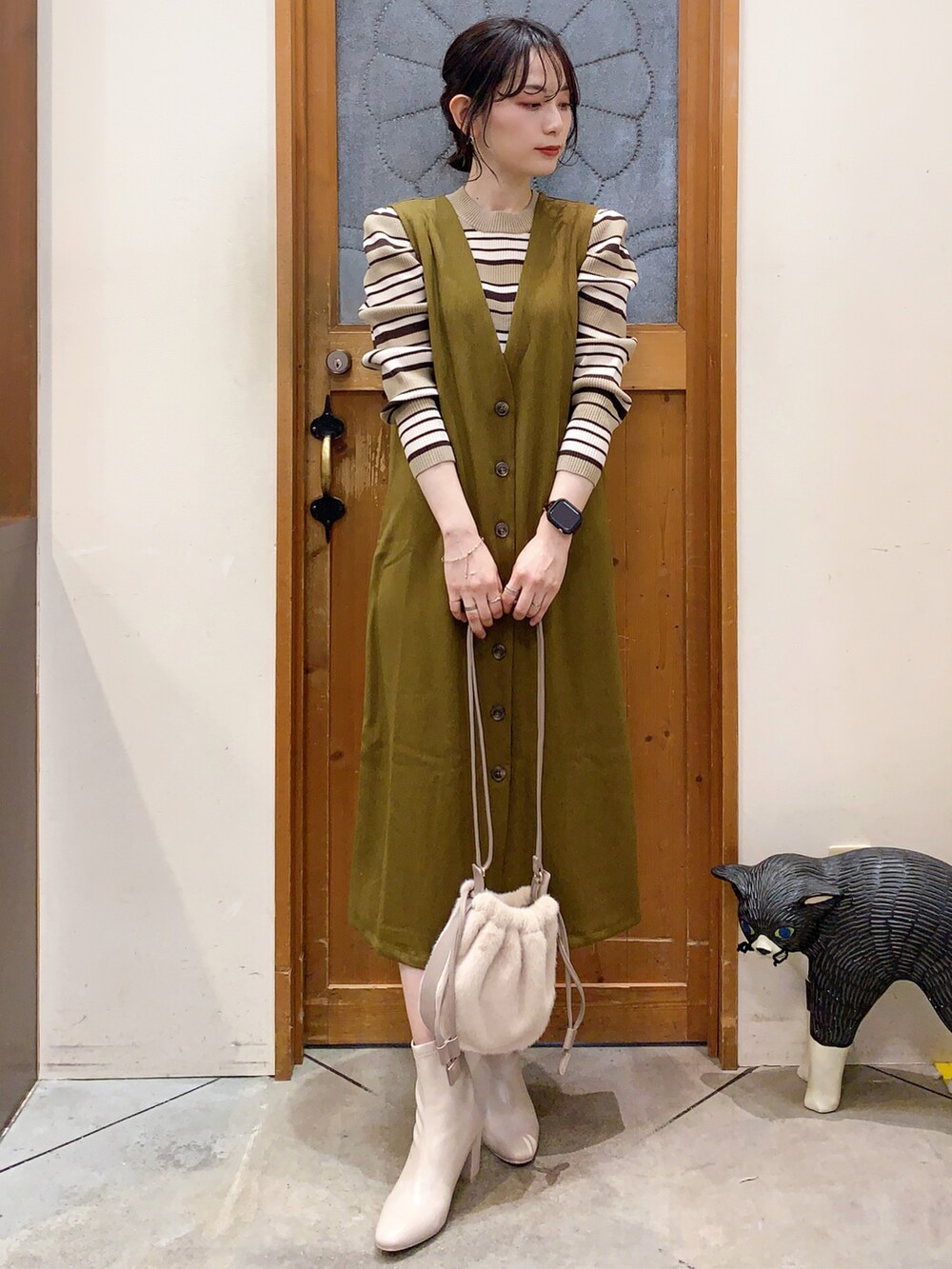 ベージュ系のニット/セーター、イエロー系のスカート、ベージュ系のショルダーバッグを着用したレディースの冬コーディネートの2枚目の写真