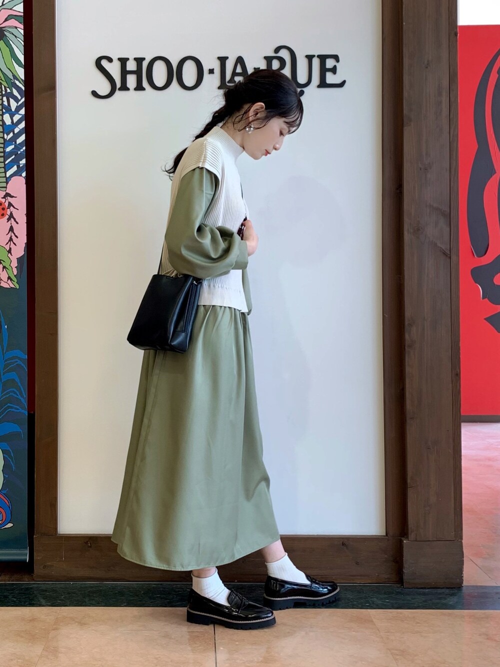 グリーン系のワンピース、ブラック系のショルダーバッグ、ブラック系のその他シューズを着用したレディースの冬コーディネートの2枚目の写真