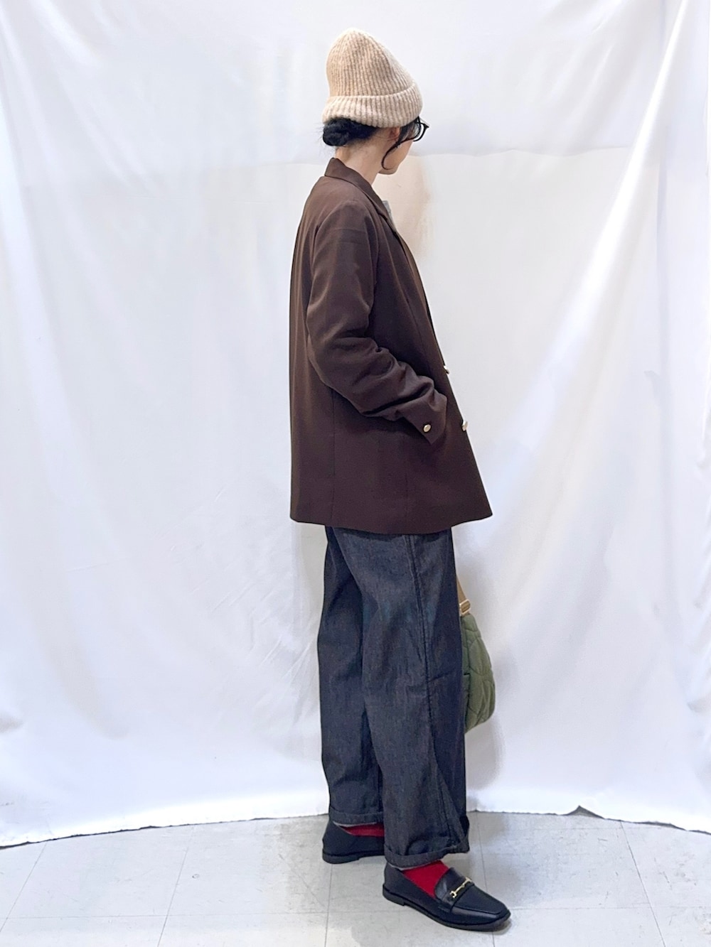 ブラウン系のテーラードジャケット、グレー系のニット/セーター、ブラック系のサロペット/オーバーオールを着用したレディースの秋コーディネートの4枚目の写真