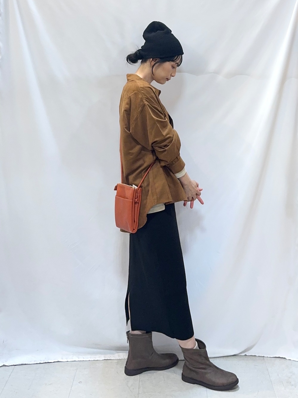 イエロー系のシャツ/ブラウス、ベージュ系のTシャツ/カットソー、ブラック系のスカートを着用したレディースの秋コーディネートの2枚目の写真