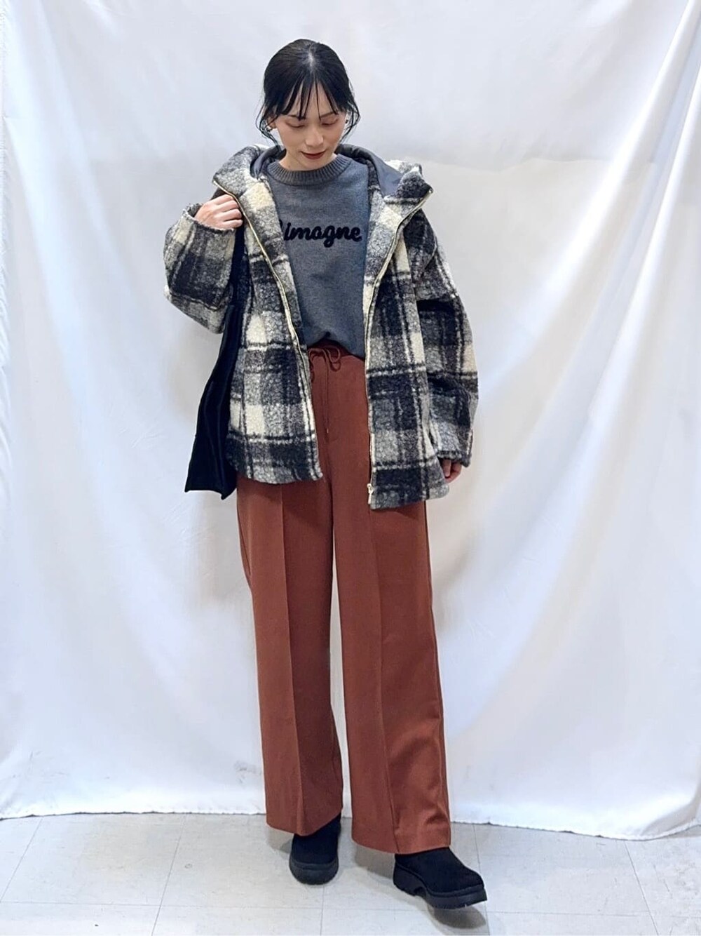ブラック系のその他アウター、グレー系のニット/セーター、レッド系のその他パンツを着用したレディースの冬コーディネートの2枚目の写真