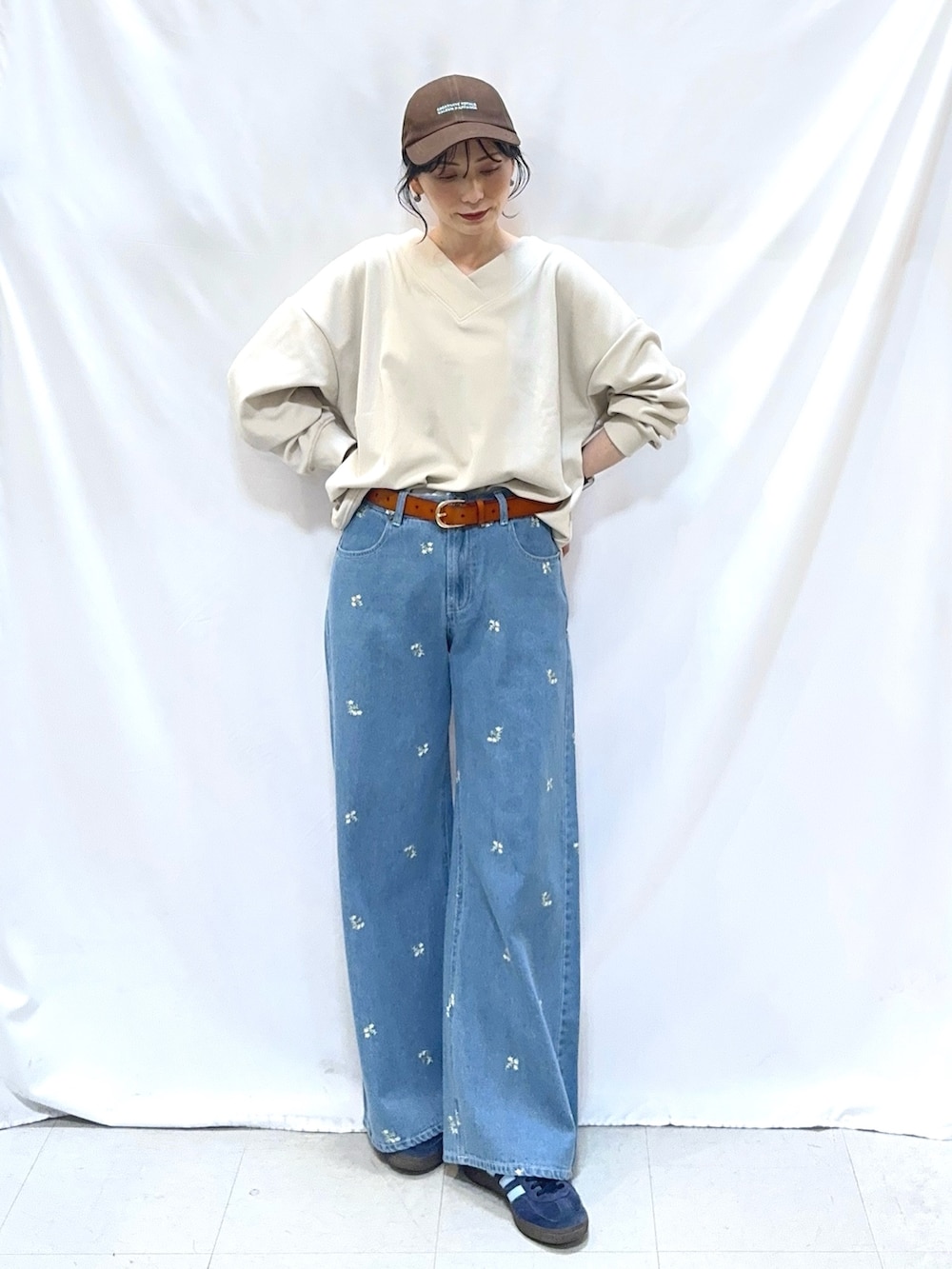 ベージュ系のTシャツ/カットソー、ブルー系のデニムパンツ、イエロー系のベルトを着用したレディースの冬コーディネートの2枚目の写真