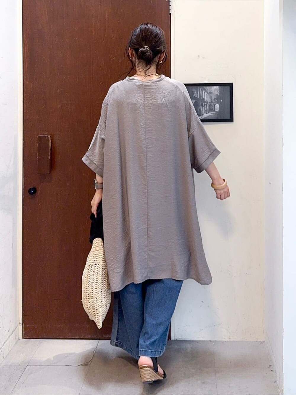 ブラウン系のチュニック、ブルー系のデニムパンツ、ブラック系のサンダルを着用したレディースの夏コーディネートの5枚目の写真