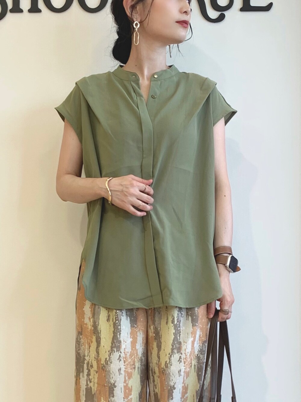 グリーン系のシャツ/ブラウス、レッド系のその他パンツ、ブラウン系のトートバッグを着用したレディースの夏コーディネートの4枚目の写真