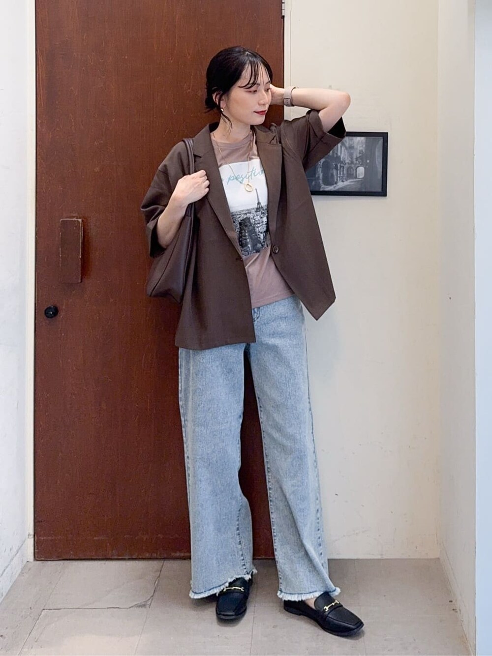 ブラウン系のテーラードジャケット、イエロー系のTシャツ/カットソー、ブルー系のデニムパンツを着用したレディースの秋コーディネートの2枚目の写真