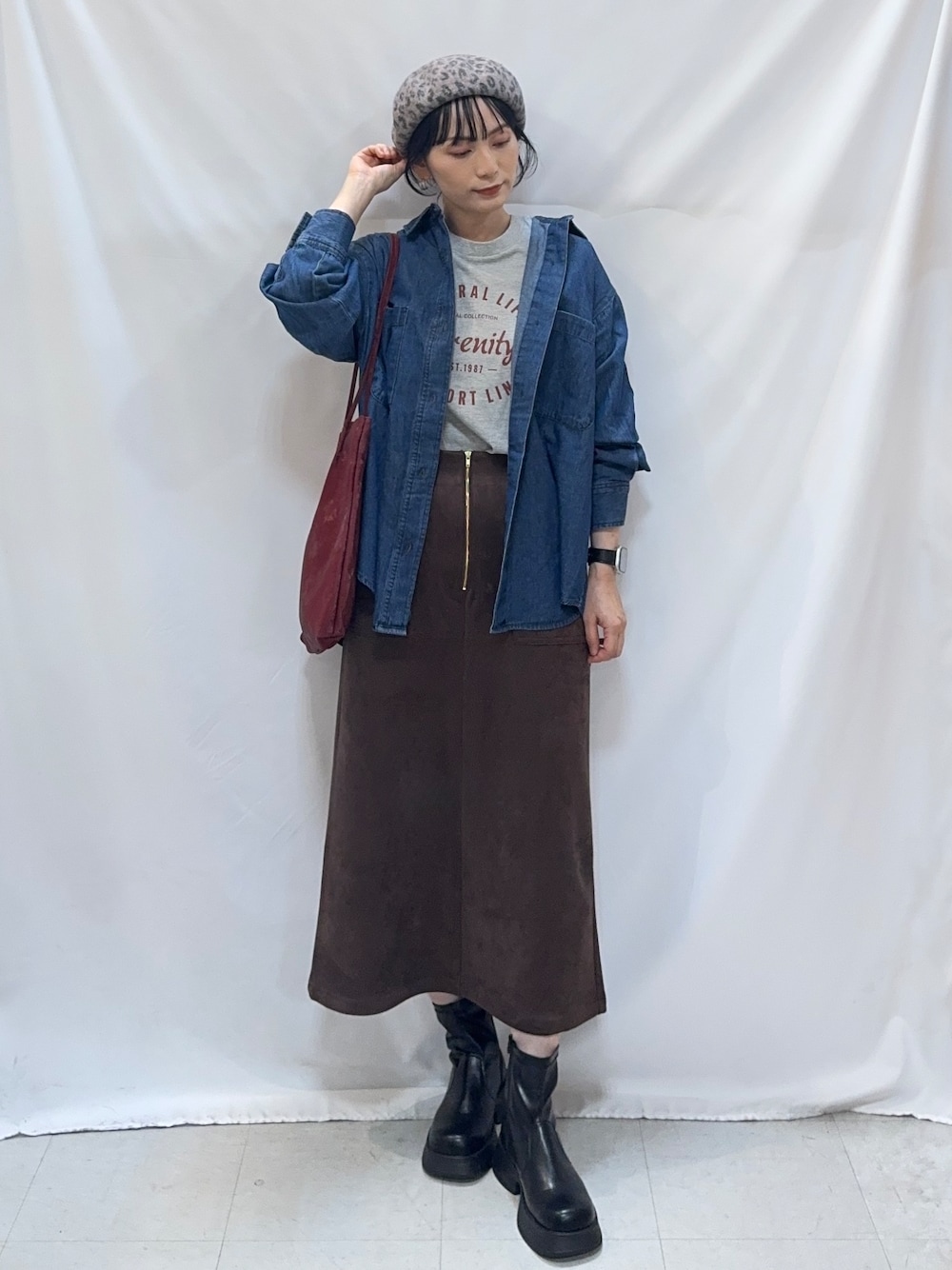 ブルー系のシャツ/ブラウス、グレー系のTシャツ/カットソー、ブラウン系のスカートを着用したレディースの秋コーディネートの4枚目の写真