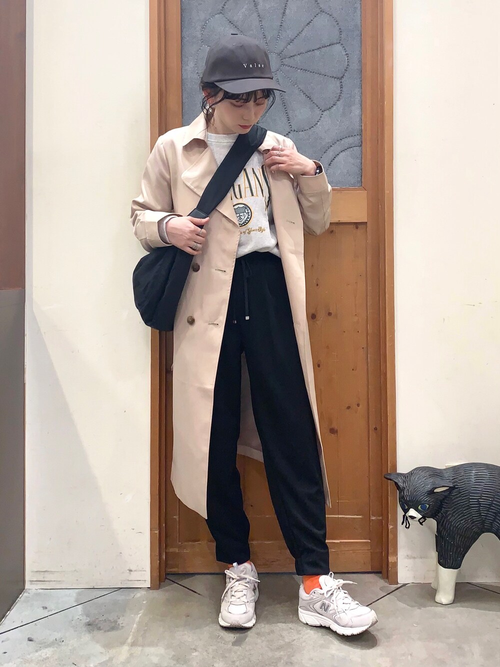 ベージュ系のトレンチコート、グレー系のスウェット、ブラック系のその他パンツを着用したレディースの冬コーディネートの2枚目の写真