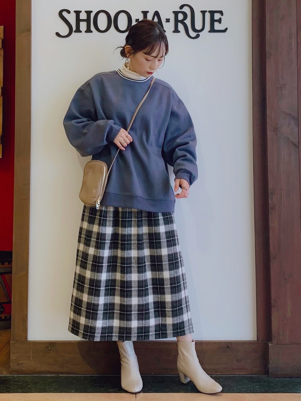 ブルー系のスウェット、ホワイト系のTシャツ/カットソー、ブラック系のスカートを着用したレディースの秋コーディネートの2枚目の写真