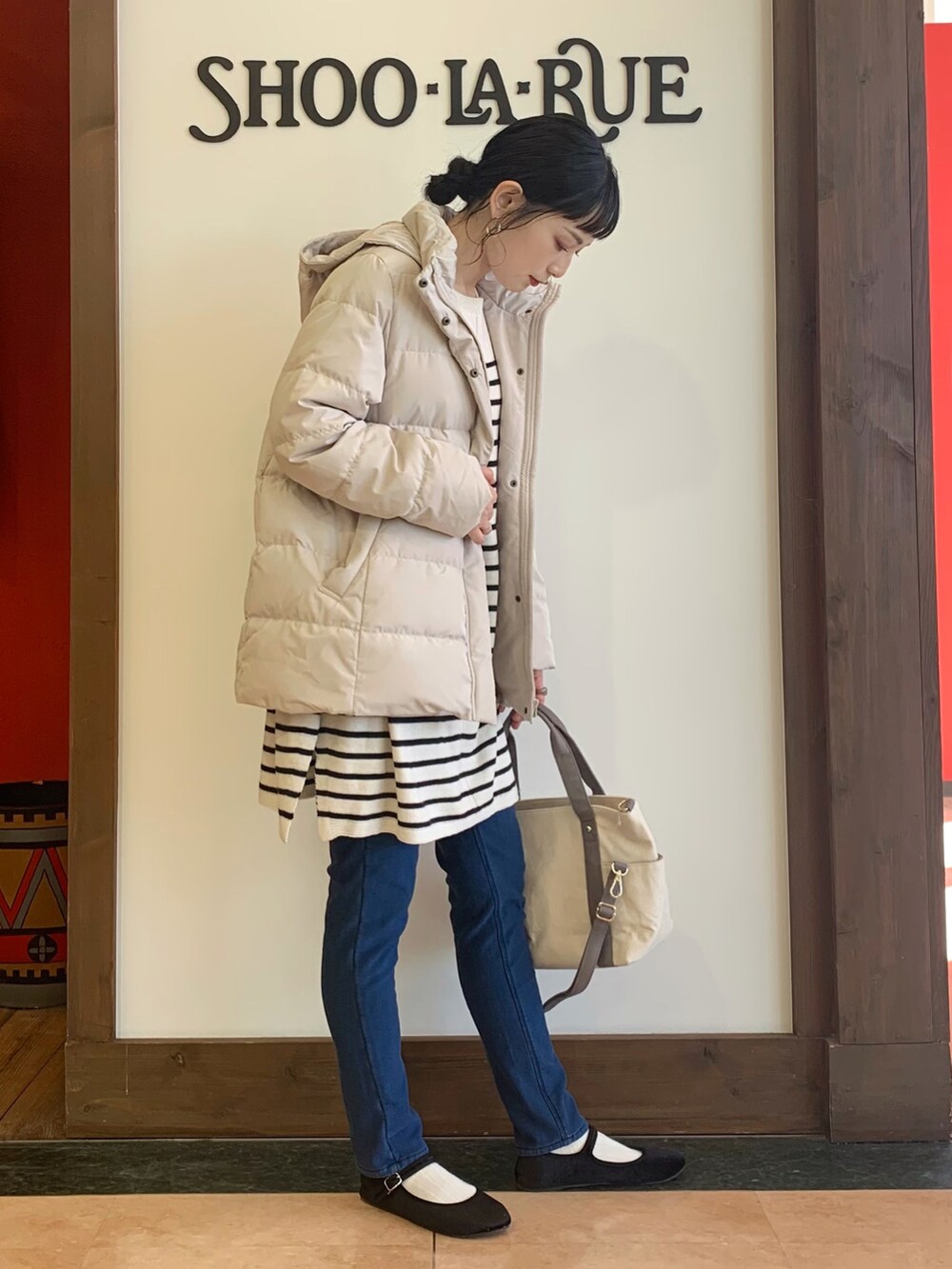 ベージュ系のワンピース、ベージュ系のダウンジャケット/コート、ベージュ系のトートバッグを着用したレディースの冬コーディネートの2枚目の写真