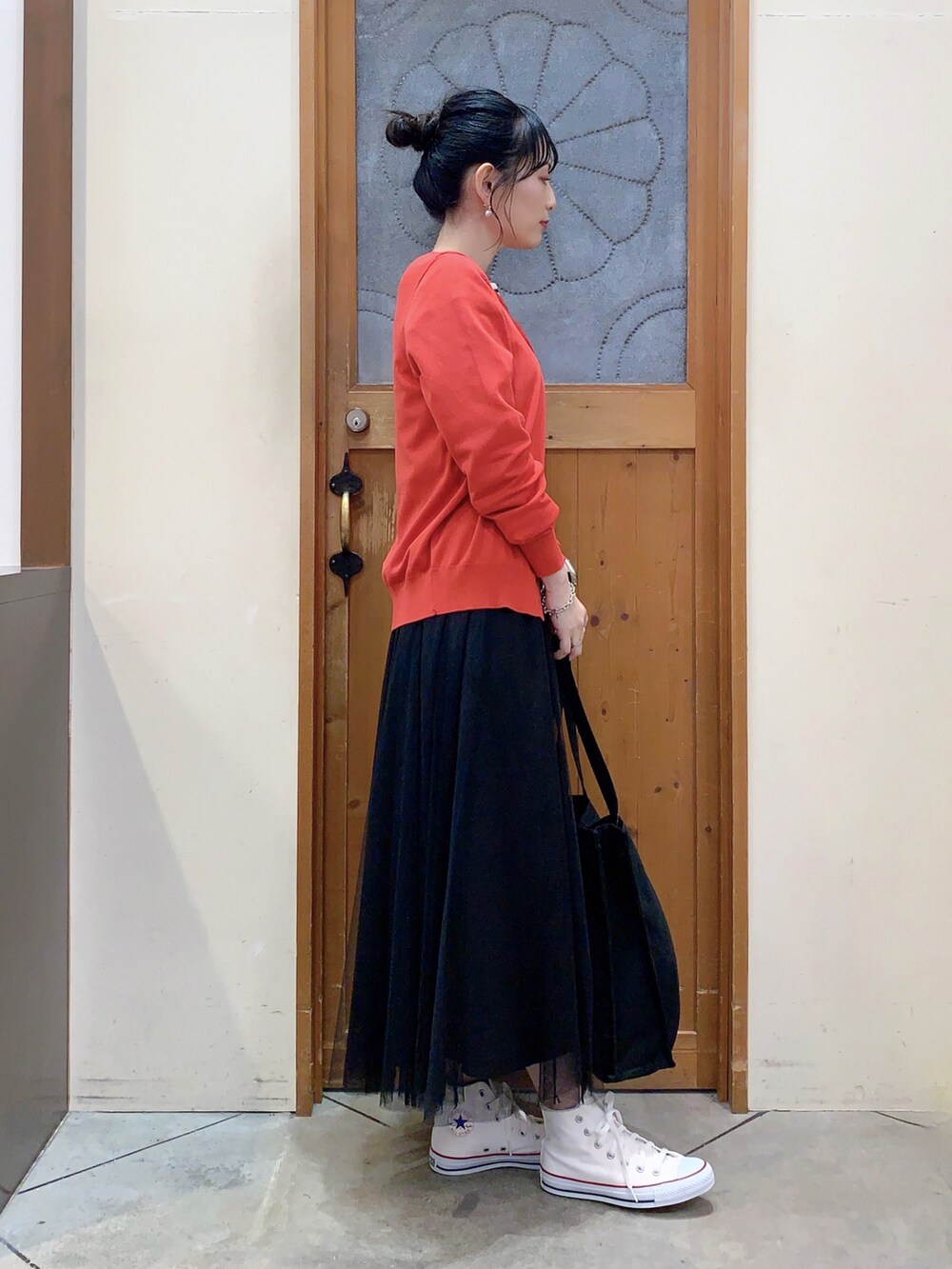 ブラック系のTシャツ/カットソー、レッド系のカーディガン/ボレロ、ブラック系のスカートを着用したレディースの春コーディネートの3枚目の写真