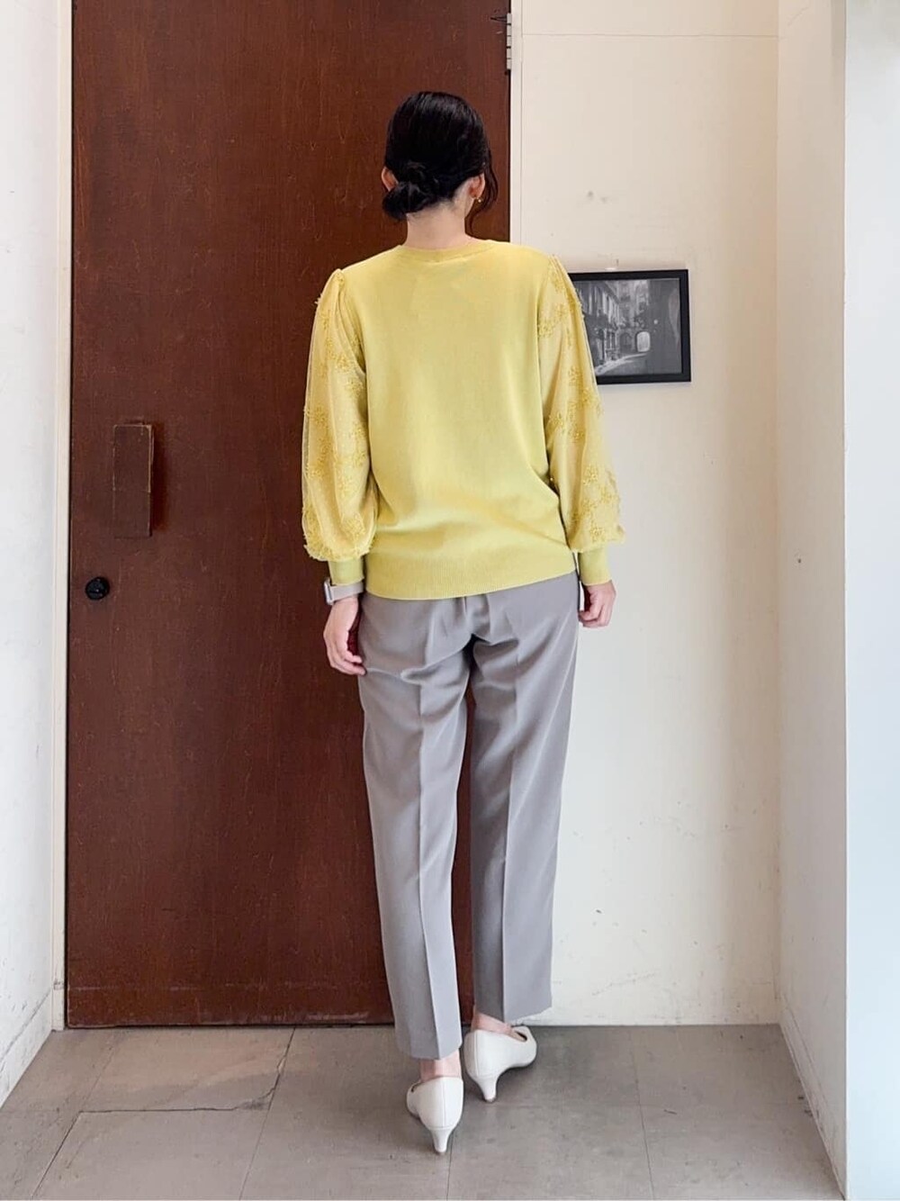 イエロー系のニット/セーター、ブラウン系のその他パンツ、ホワイト系のパンプスを着用したレディースの春コーディネートの4枚目の写真