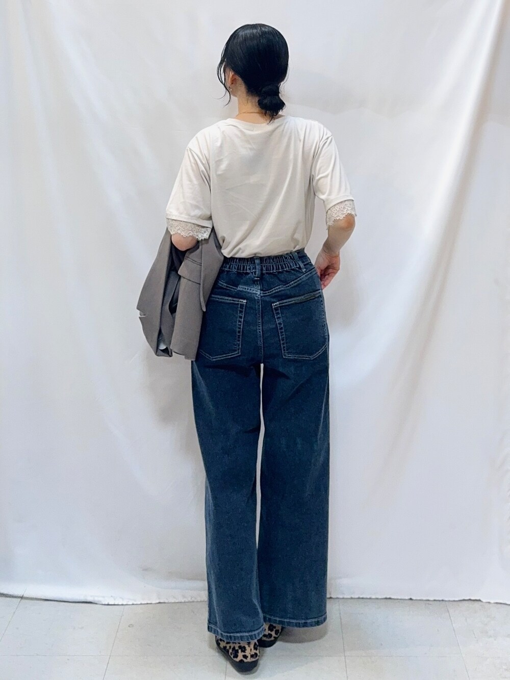 ブラウン系のテーラードジャケット、ベージュ系のTシャツ/カットソー、ブルー系のデニムパンツを着用したレディースの秋コーディネートの6枚目の写真