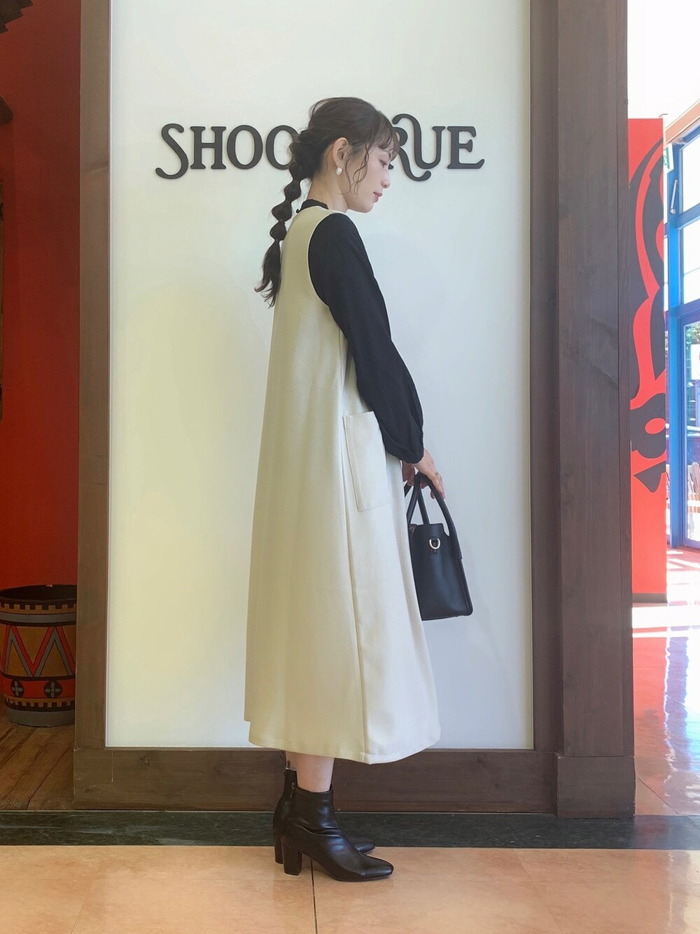 ブラック系のワンピース、ブラック系のシャツ/ブラウス、ブラック系のトートバッグを着用したレディースの冬コーディネートの3枚目の写真