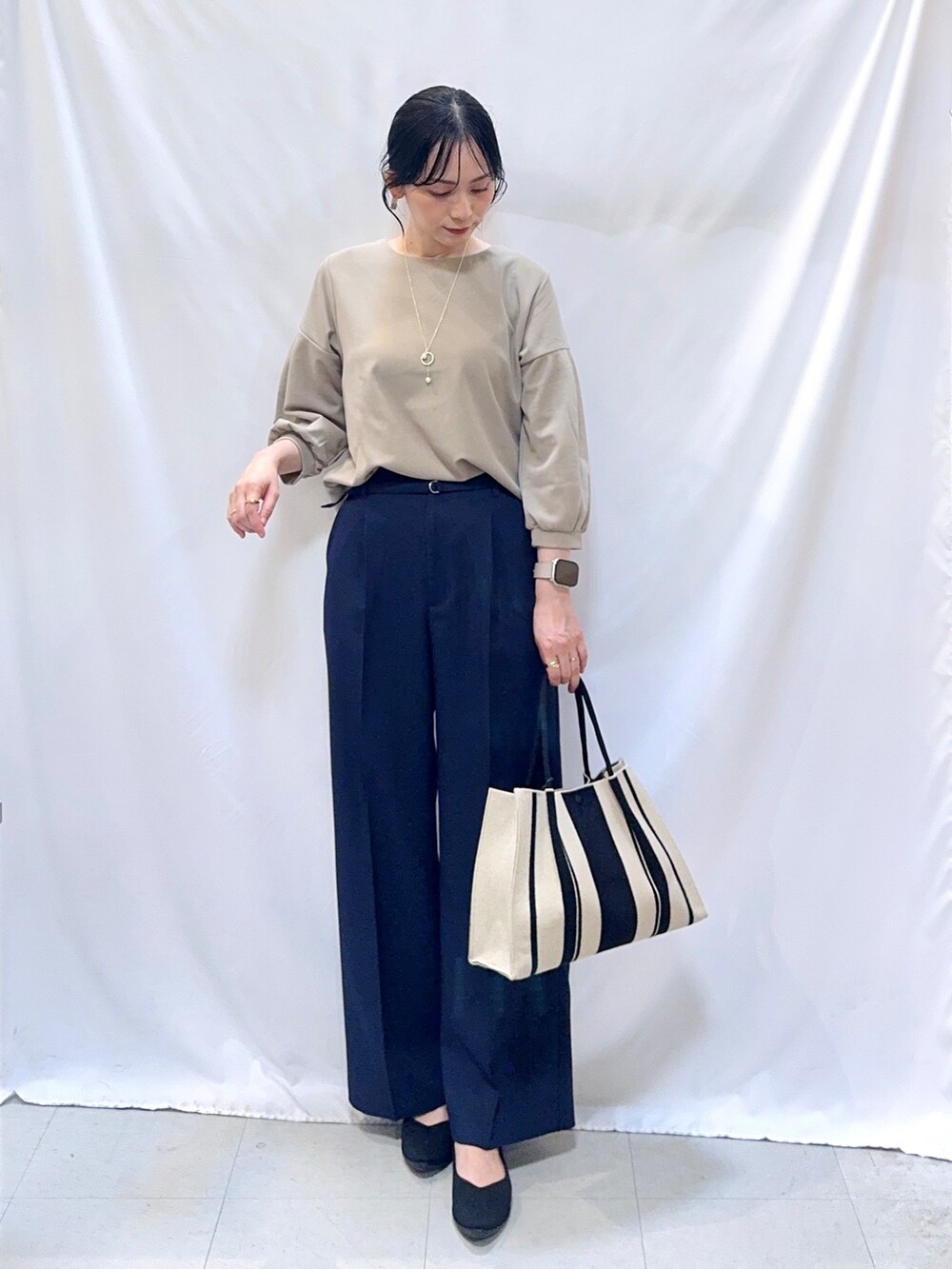 ブルー系のその他パンツ、ブラック系のパンプス、ブラック系のトートバッグを着用したレディースの秋コーディネートの5枚目の写真